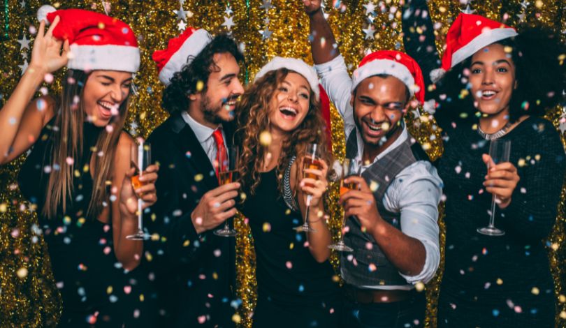 image of people celebrating with santa hats on and champagne
