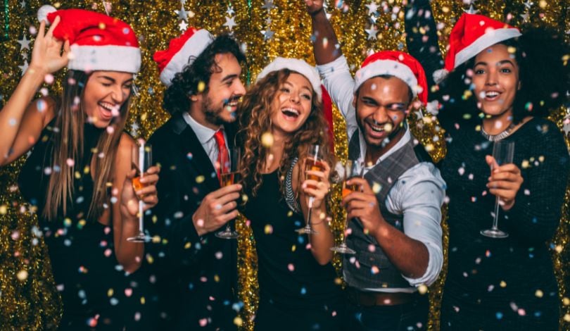 image of people celebrating with santa hats on and champagne