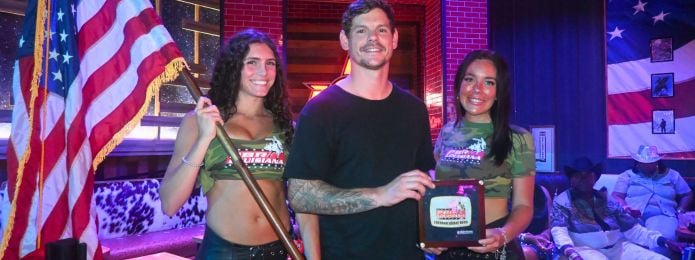 image of three people, one holding an american flag, and the other two are both holding a belt buckle
