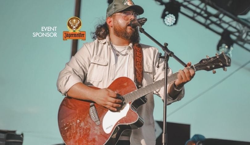 image of brody rivers band lead singer holding a guitar and singing into a mic on stage
