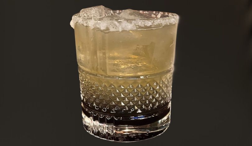 image of a purple and gold cocktail with a black background
