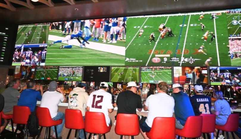 image of men sitting at a bar watching sports at sports and social louisiana with a 110 ft media wall