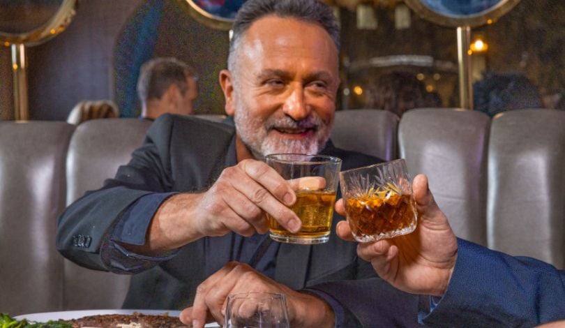 image of a man toasting a whiskey glass