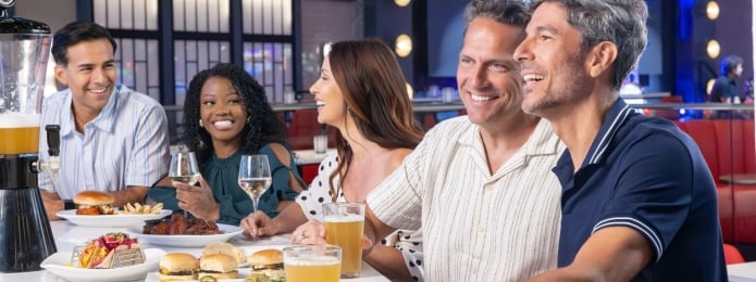5 people sitting at the bar at Sports & Social while enjoying happy hour specials
