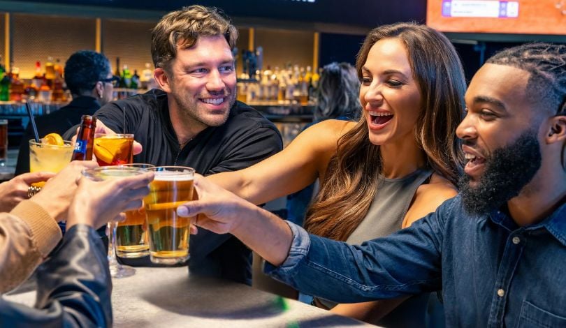 photo of 3 people clinking glasses together at sports & social