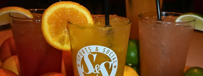 image of 4 citrus cocktails with fruit on the table surrounding them