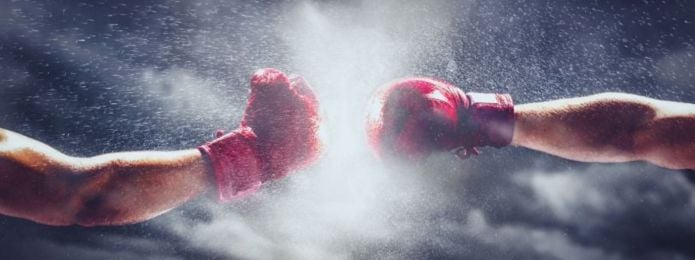 image of two boxing gloves punching towards each other