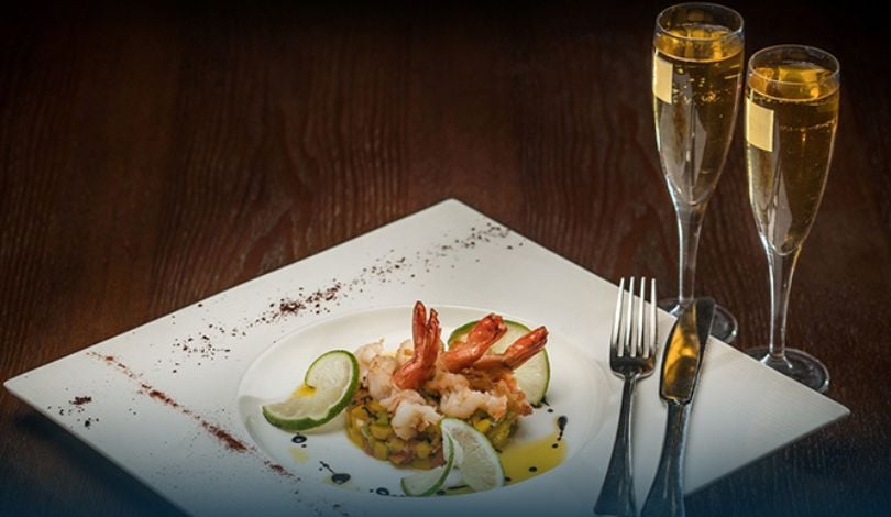 photo of shrimp dish and two champagne glasses
