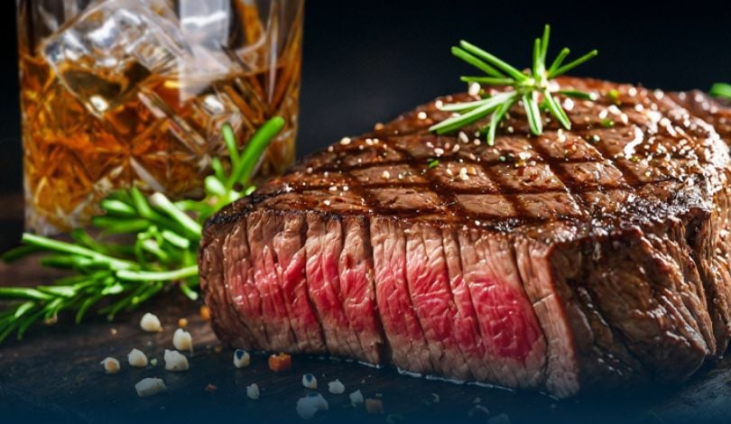 image of a steak and a bourbon in a glass