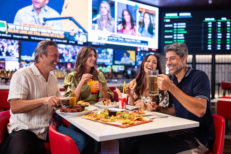 Two couples having drinks and dinner at Sports & Social