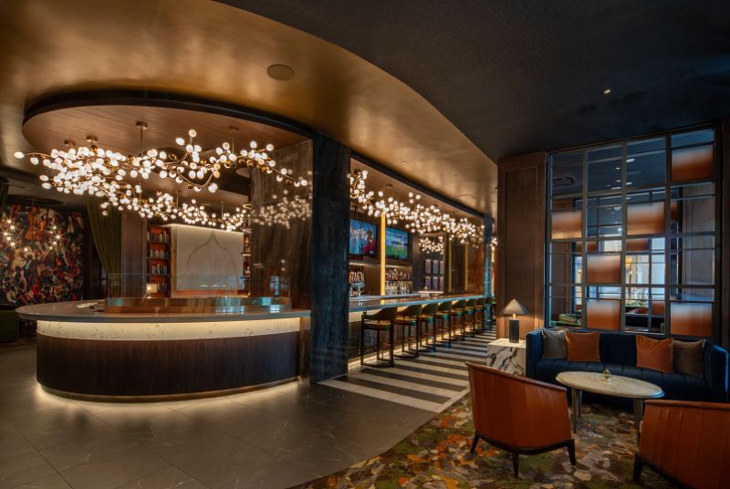 Bar area with bubble light fixture hanging from above. Couch and large chair seating on the right side of the photo.