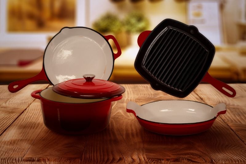 Fall into Flavor Gift Giveaway. Four types of pots/pans/bakeware that are all a dark red color sitting on a wooden table.