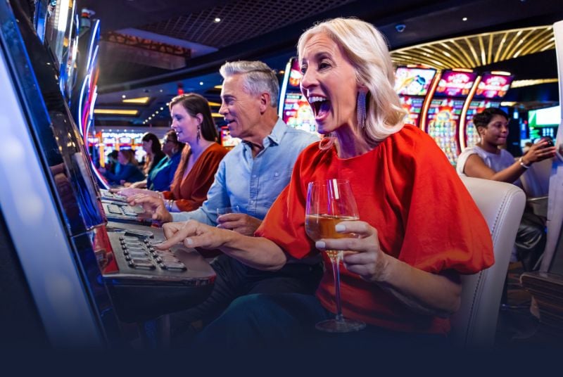 Veterans Day Salute and Celebrate. 3 people sitting at a slot machine inside of a casino that show excitement to be there.