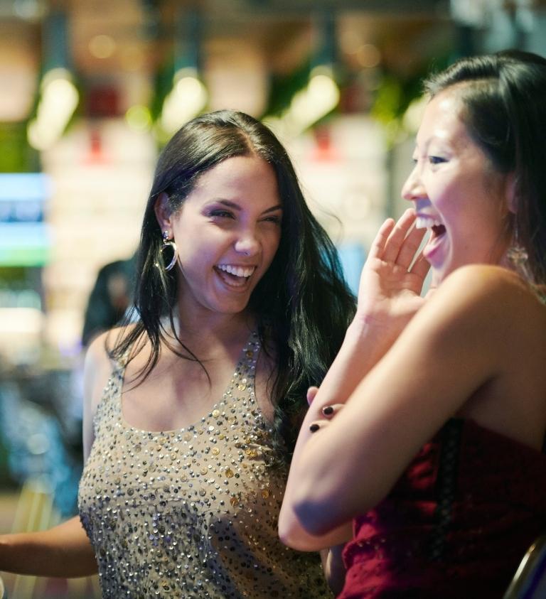 Two Women Playing Slots in Orchid Gaming & Smoking Patio®