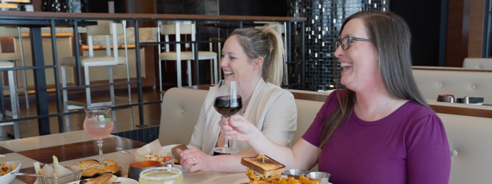 summer of savings laughing at restaurant table