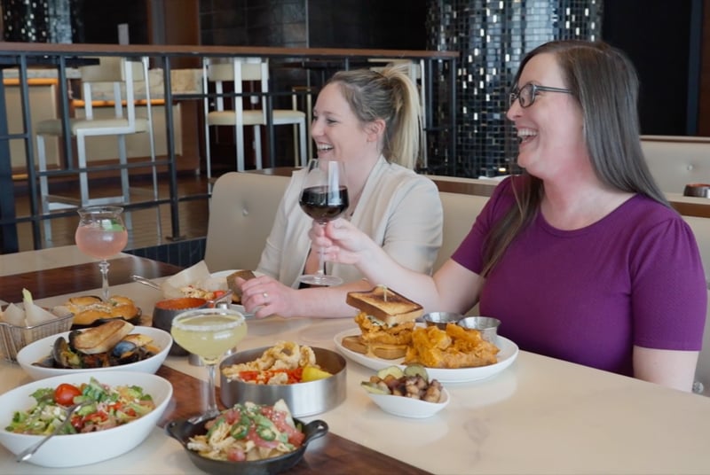 summer of savings laughing at restaurant table