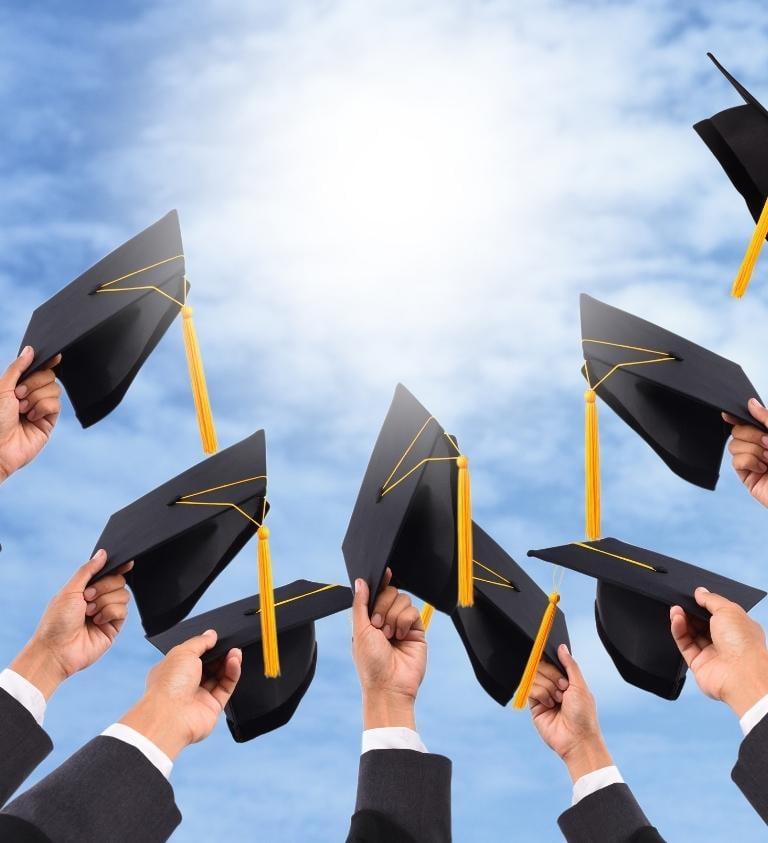 Group Holding Graduation Caps in the Air