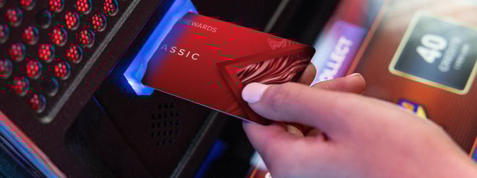 a player inserting their live rewards card into a machine