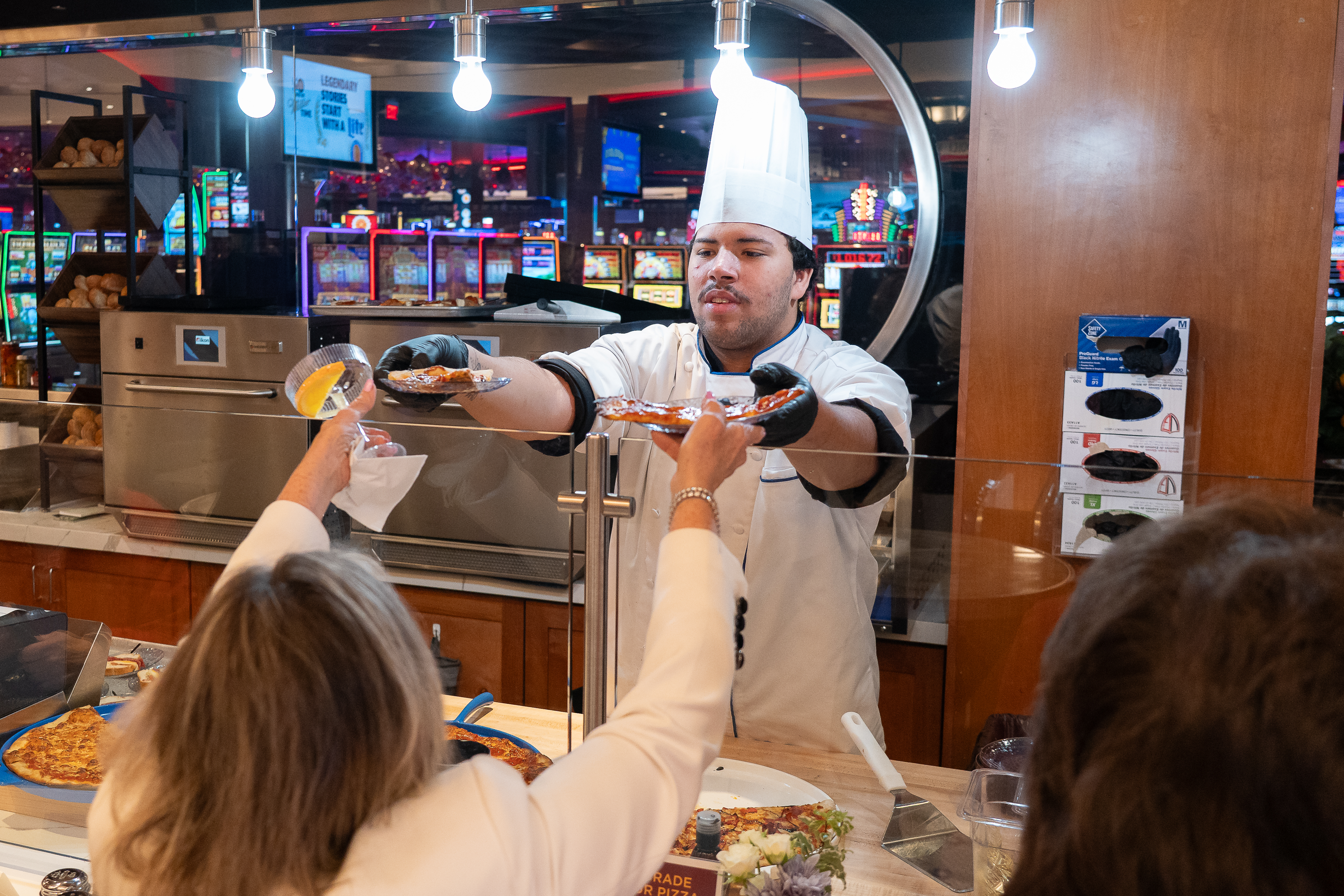 chef at mangia handing food to customers