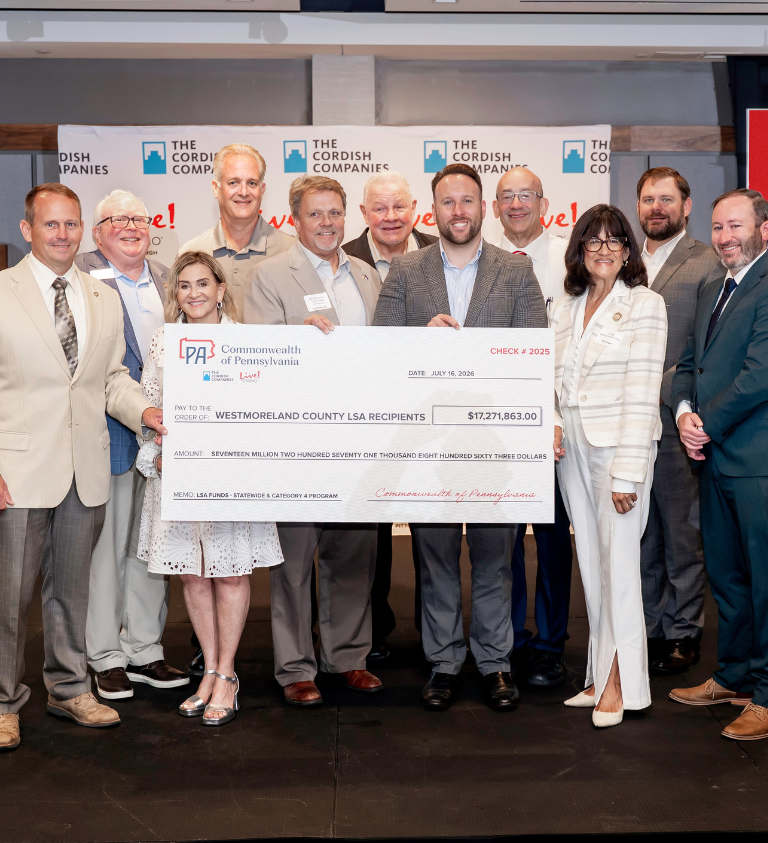 sean sullivan and other local leaders hold a giant check