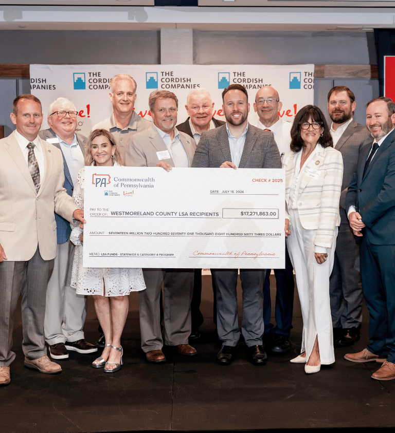 sean sullivan and other local leaders hold a giant check