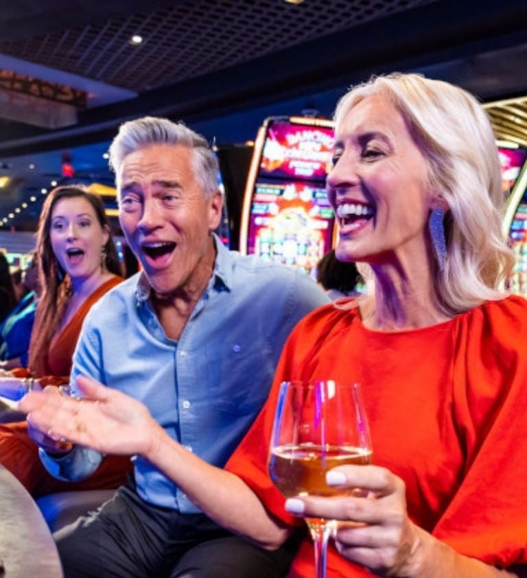 Guests playing on slot machines and celebrating hitting the jackpot.