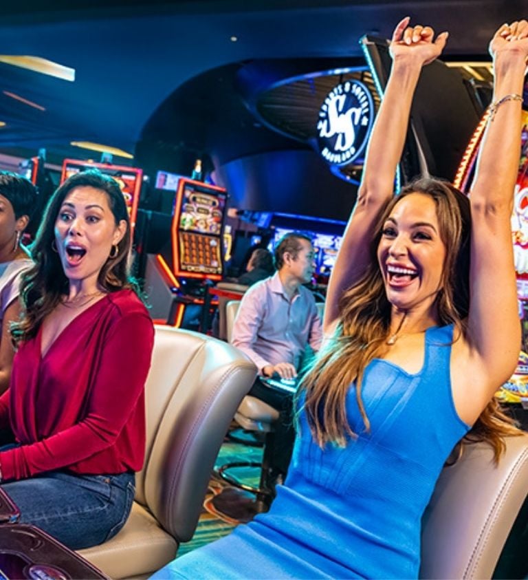 Guests playing on slot machines and celebrating hitting the jackpot.