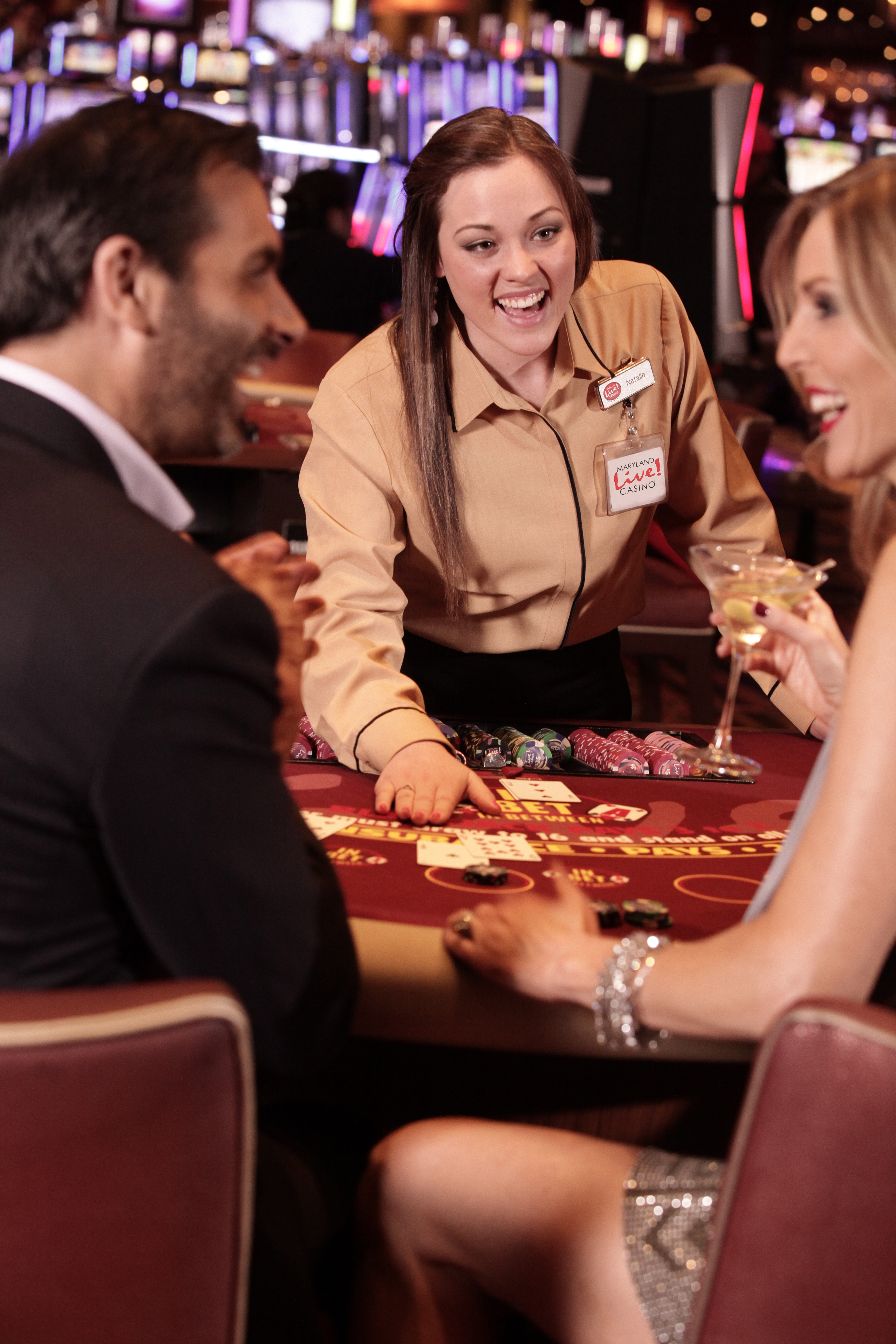 casino dealer dealing cards to players playing table games