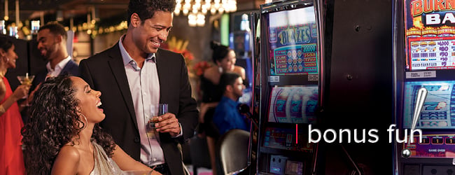 players smiling and looking at a slot machine in the casino