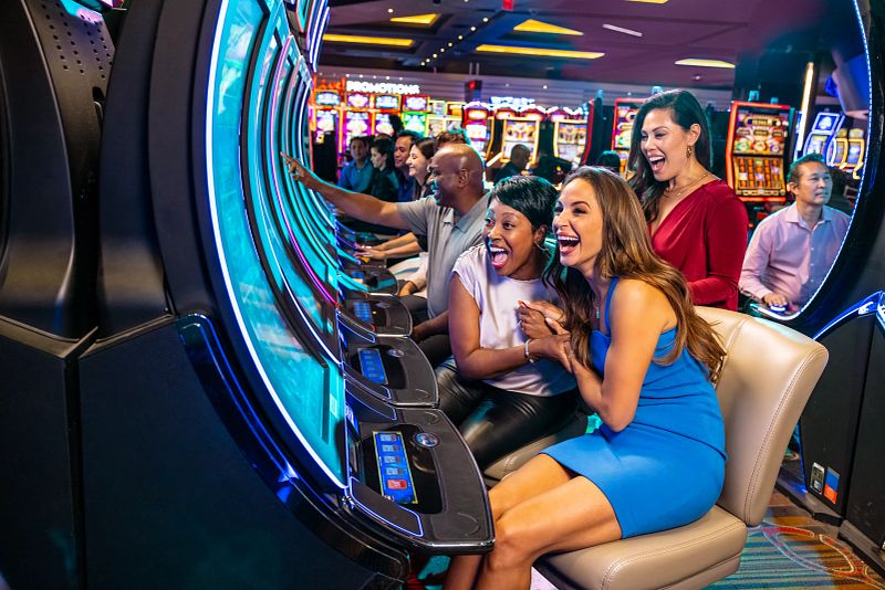 Guests playing on slot machines and celebrating hitting the jackpot.