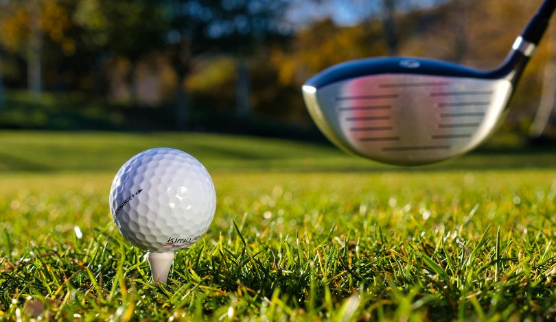 image of a white golf ball on a white tee in the grass
