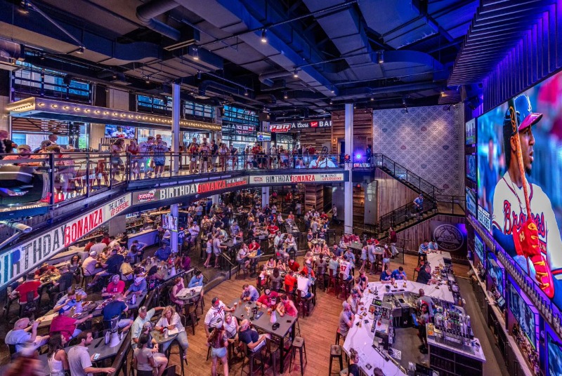 Fans cheer the Braves on as the game airs on a 40-foot diagonal high-definition LED screen at Sports & Social.