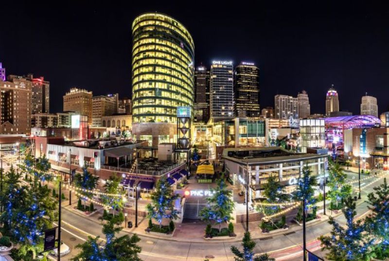 A panoramic view of the gorgeous nighttime city lights, buildings, and trees in Kansas City's Power & Light District.