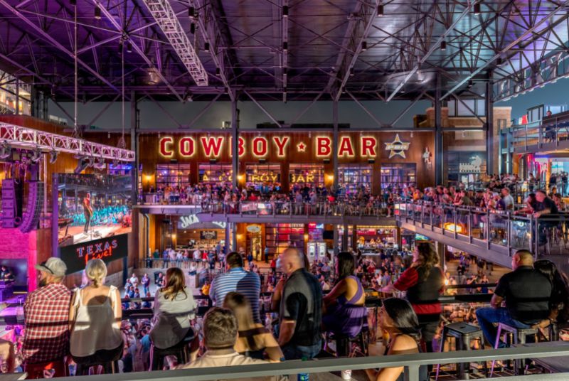 Looking across the balcony at the two-story PBR Cowboy Bar as the crowd watches live music on stage and a giant LED screen!