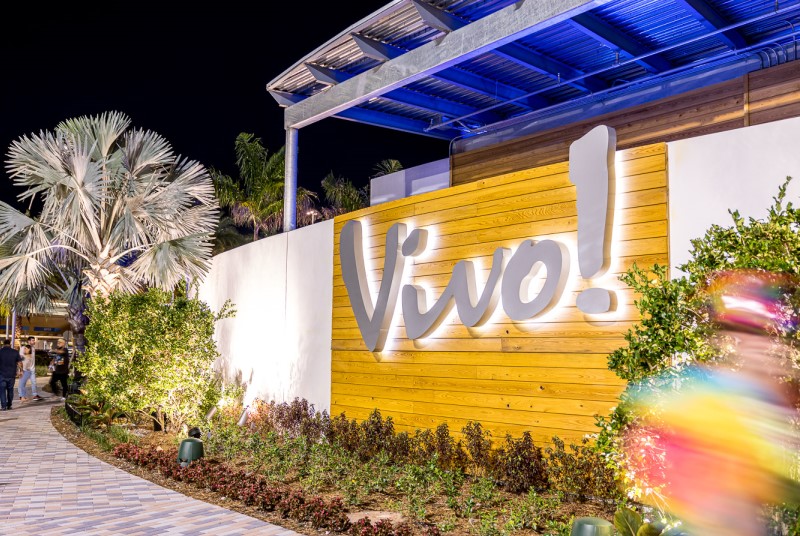 Vivo! illuminated exterior entrance sign and walkway at night.