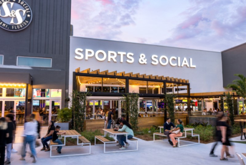 Sports and Social outdoor patio area with seating and people walking through.