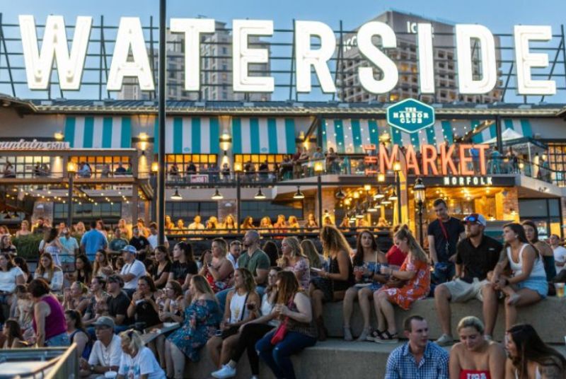 Evening descends in the Waterside District as fans gather on the steps below The Market before a Hot Country Nights concert.