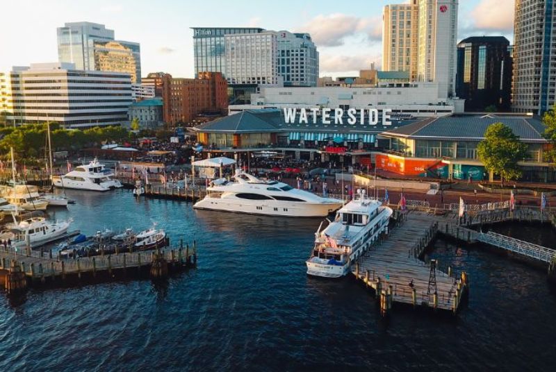 An aerial view of many boats docked beside the Waterside District and the buildings that surround it.