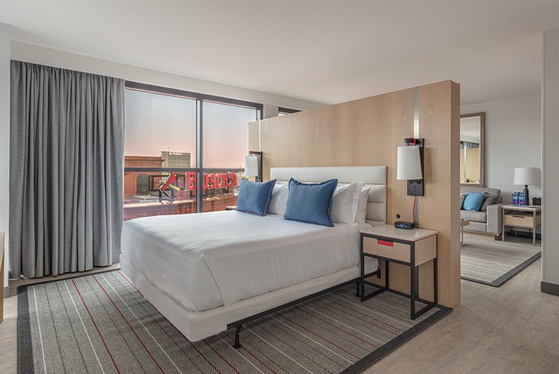 This modern hotel suite artfully divides the space between rooms with a 3/4 wall and features a perfect Busch Stadium view.