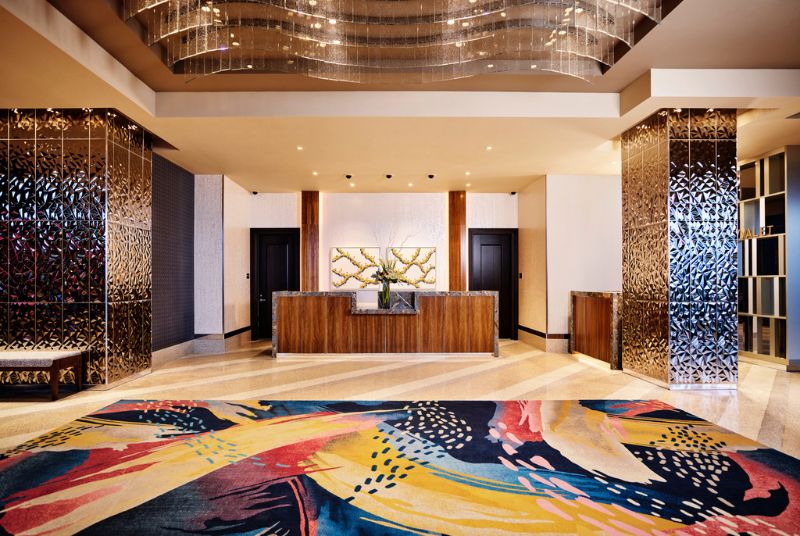The lobby has stunning ceiling art of flowing glass ribbons while hammered gold support beams border the check-in area.