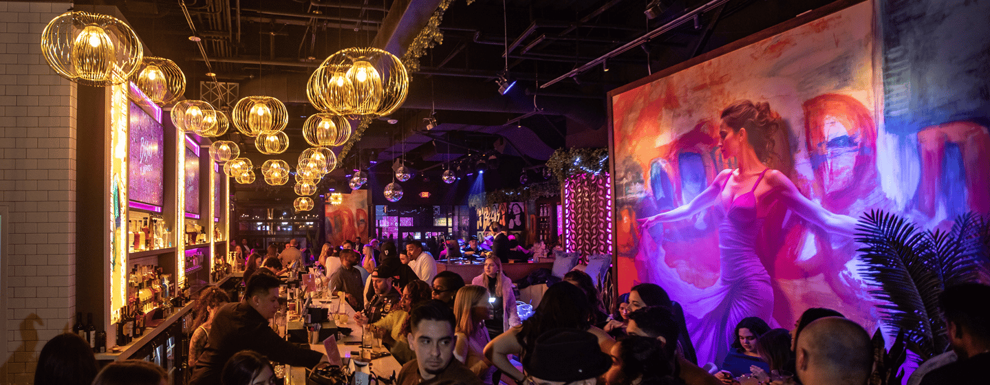 Lively crowd at Bezos y Abrazos bar in the evening.