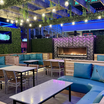 Outdoor banquet seating and fireplace.