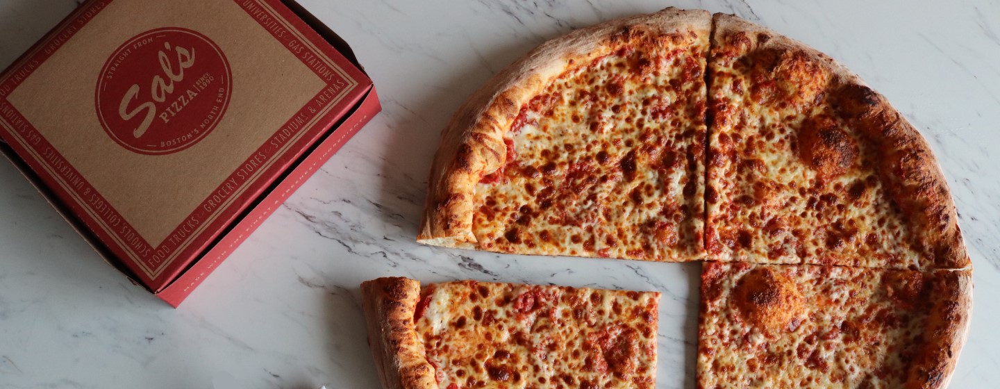 Cheese pizza cut in four slices next to Sal's Pizza box.