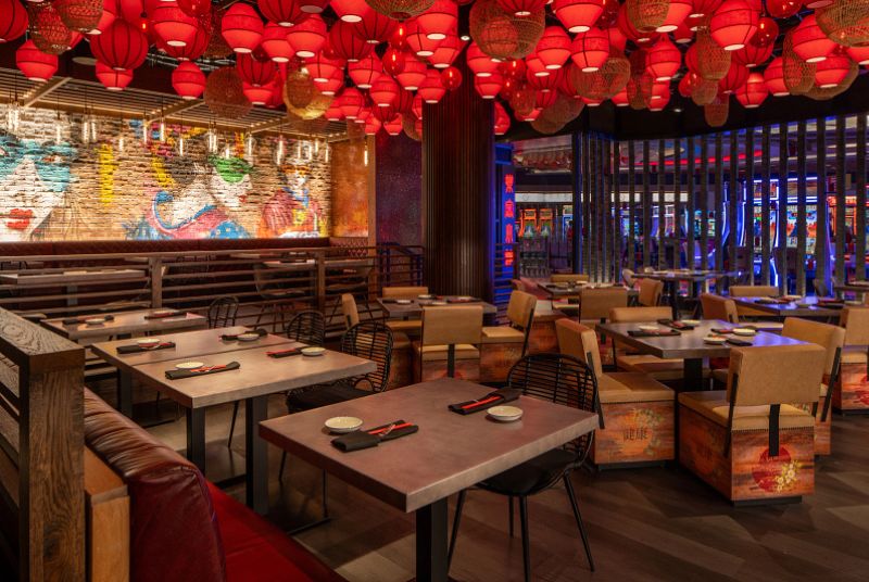 Restaurant dining room with booths and tables, red paper lanterns hanging from the ceiling. 