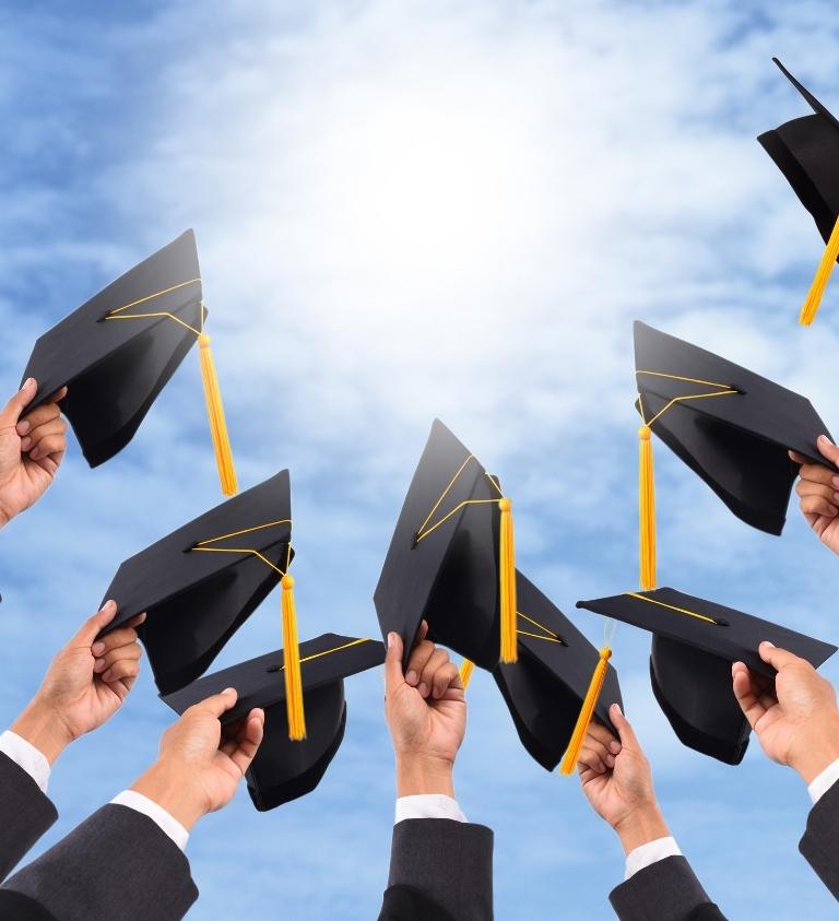 Group Holding Graduation Caps in the Air