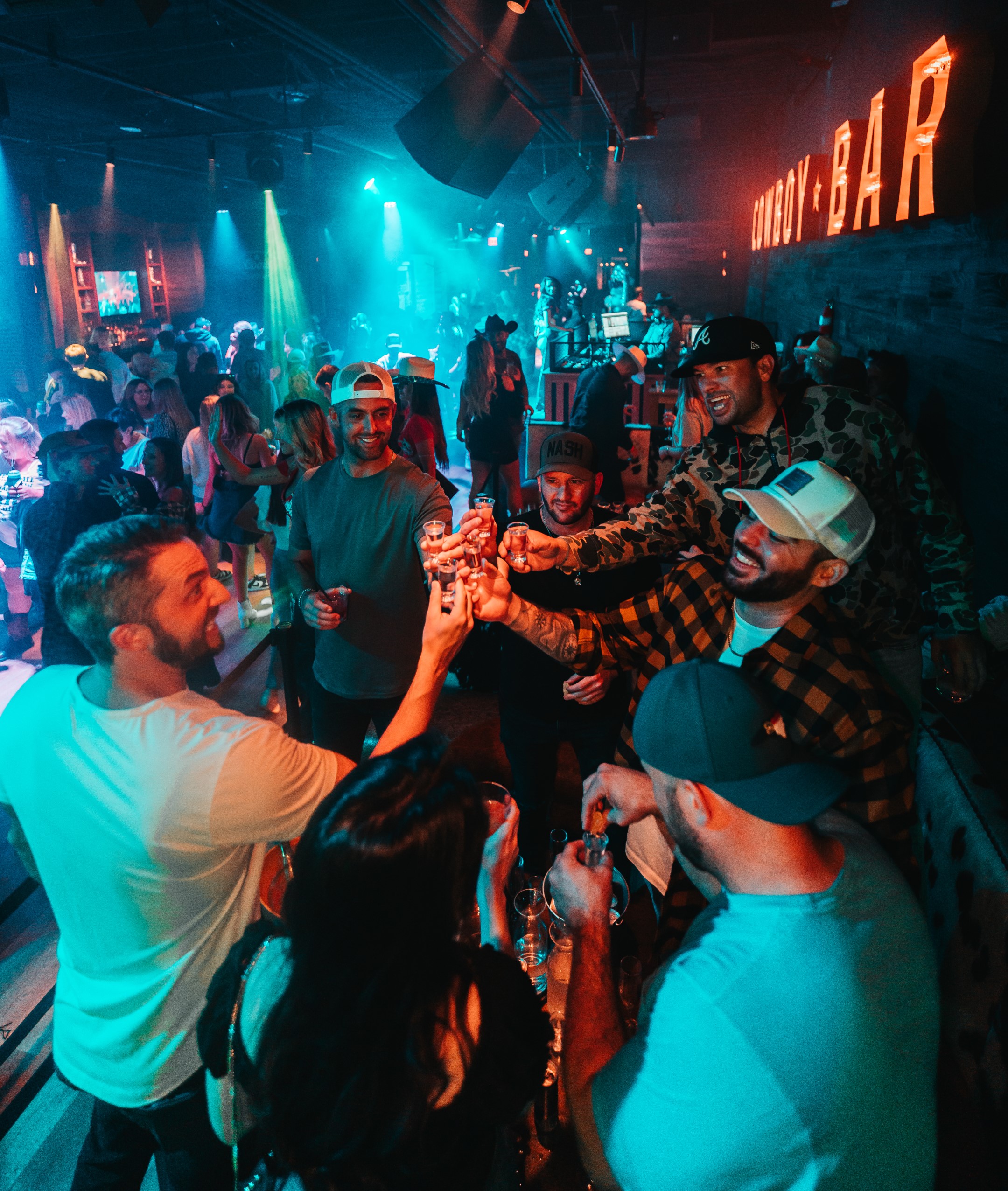 Group of men toasting drinks in a nightclub.
