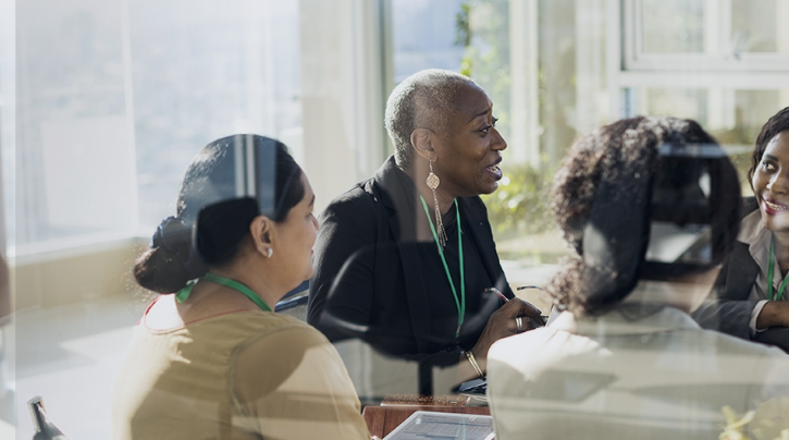 Alumni having conversation around conference room table