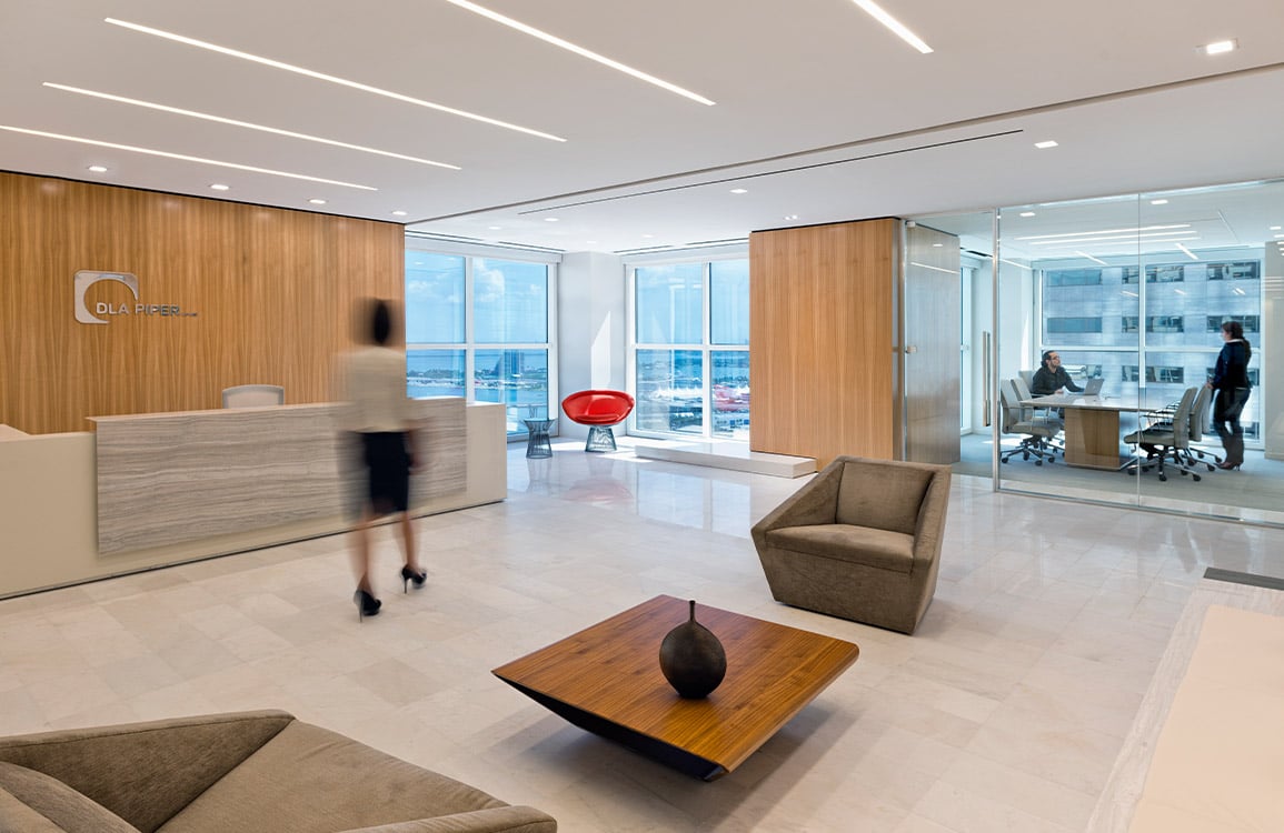 Person walking through lobby of DLA Piper office.