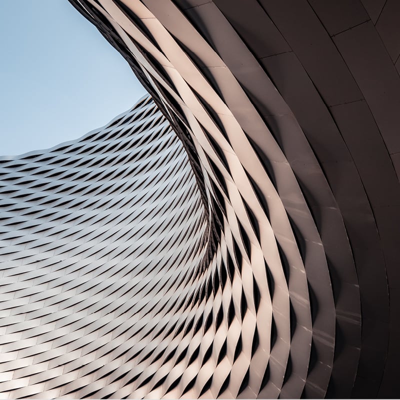 Curved building against blue sky to illustrate compliance