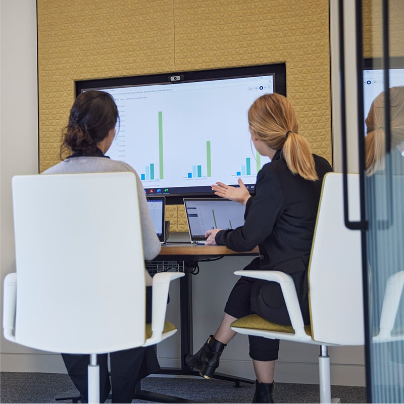 Colleagues working at a computer to illustrate antitrust and competition